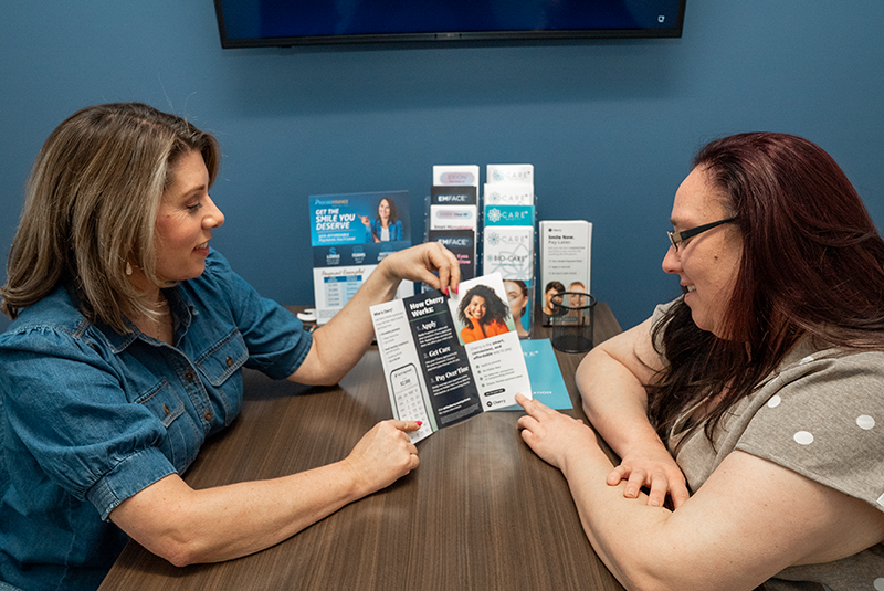 Amanda bell showing a patient a third-party cherry financing brochure